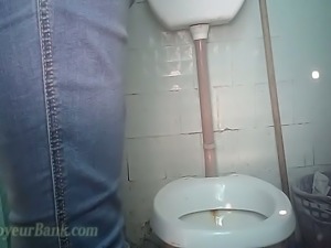 Mature white lady in blue jeans and jacket pisses in the toilet