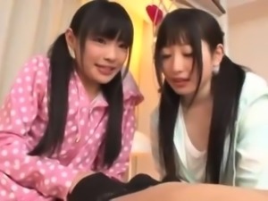 Two adorable Japanese schoolgirls take turns on a stiff cock