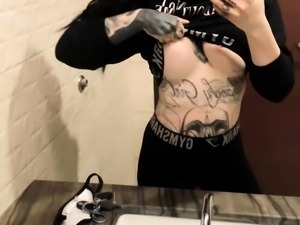Tattooed teen reveals her fabulous body in a public toilet